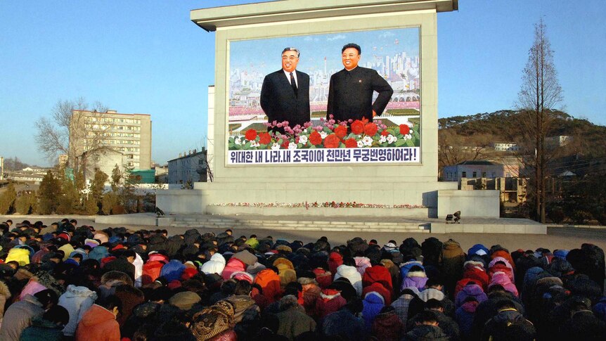 People mourn in front of a large portrait of Kim Jong Il and his father Kim Il Sung in Pyongyang.