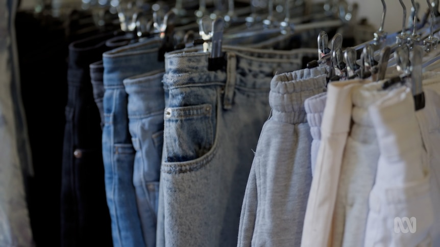 A row of jeans hanging on a rail