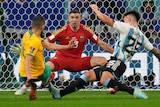 Argentina goalkeeper Emiliano Martinez spreads his arms as the Socceroos' Aziz Behich is tackled Lisandro Martinez.