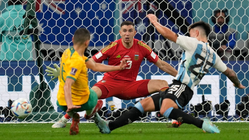 Argentina goalkeeper Emiliano Martinez spreads his arms as the Socceroos' Aziz Behich is tackled Lisandro Martinez.