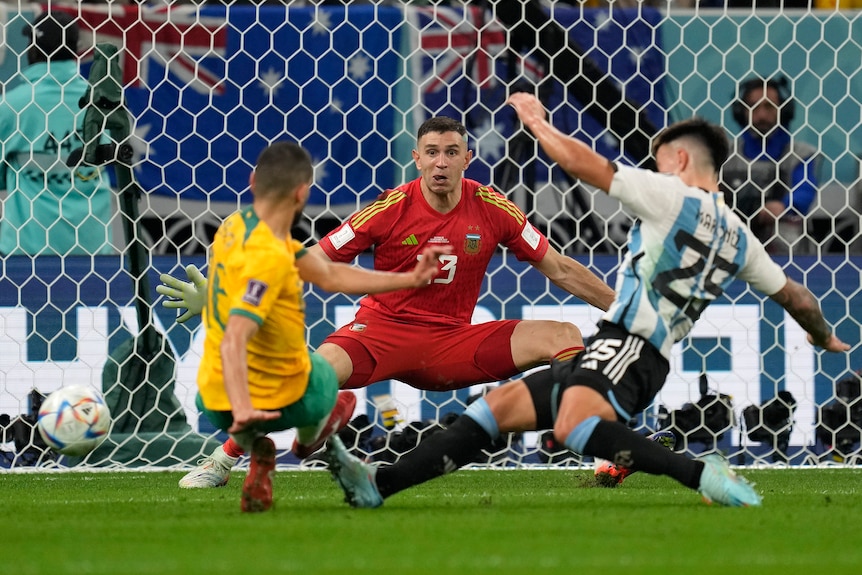 Argentina goalkeeper Emiliano Martinez spreads his arms as the Socceroos' Aziz Behich is tackled Lisandro Martinez.