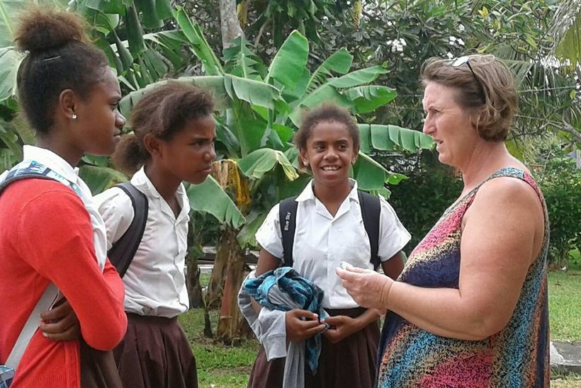 Belinda Roselli speaking to three girls in school uniform