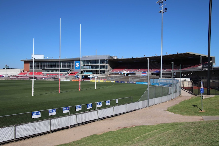 The green grounds of Whitten Oval viewed over a fence at West Footscray.