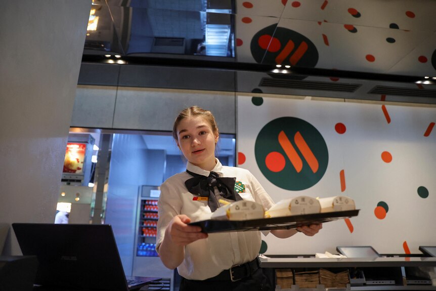 An employee takes part in preparations before the opening of the new restaurant "Vkusno & tochka".