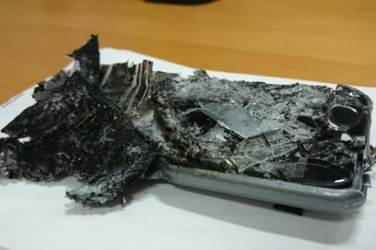 A smartphone with an entirely crushed screen and partially melted bottom half.