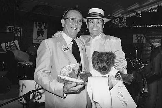 Elton John clutching a teddy bear with former Brisbane lord mayor Roy Harvey