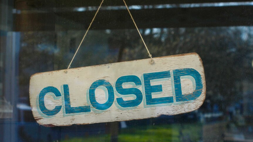A closed sign hangs inside a glass window.