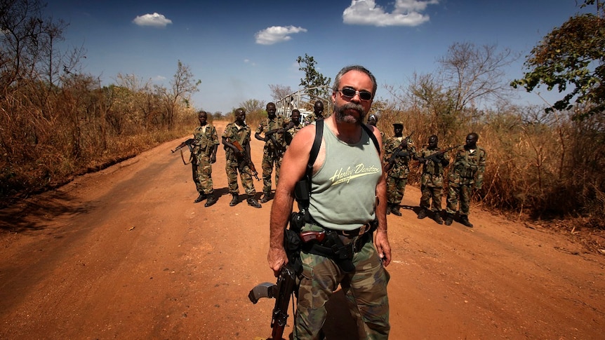 Sam Chisolm, the Machine Gun Preacher, pictured in Sudan with members of the Sudanese Peoples Liberation Army. Mr Chisolm is armed with an assault rifle with the magazines taped together so he can reload it faster.