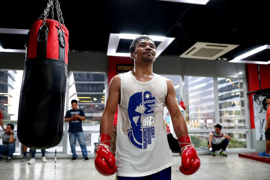Boxer Manny Pacquaio walks away from a heavy bag while training at a boxing gym