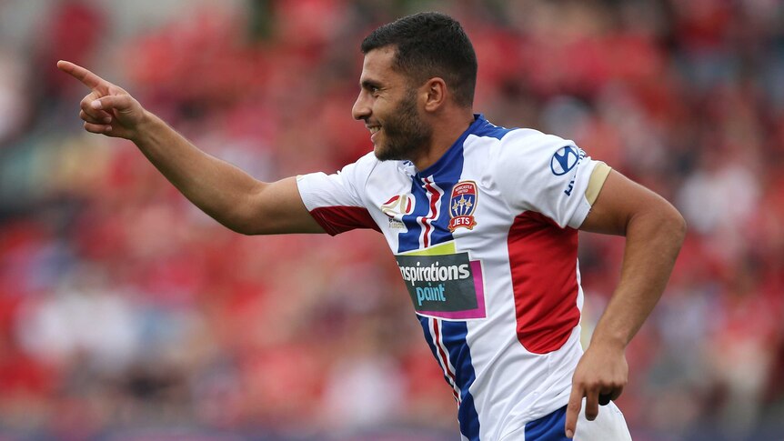 Andrew Nabbout points his finger and smiles after scoring a goal for Newcastle Jets against Adelaide United.
