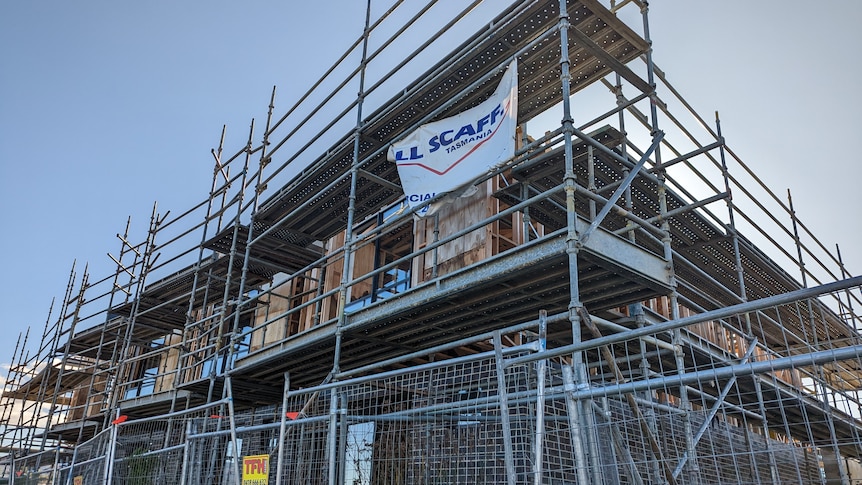 A partly completed building behind a fence