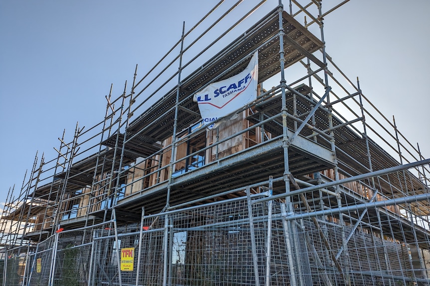 A partly completed building behind a fence