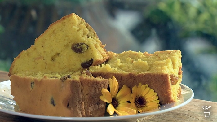 Cut yellow cake on plate with yellow flowers on the side