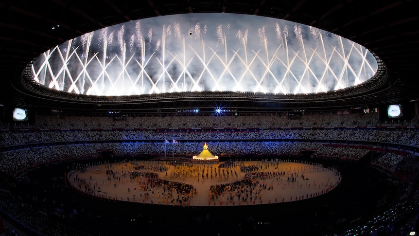 A ring of white fireworks go off around the Olympic Stadium in Tokyo.