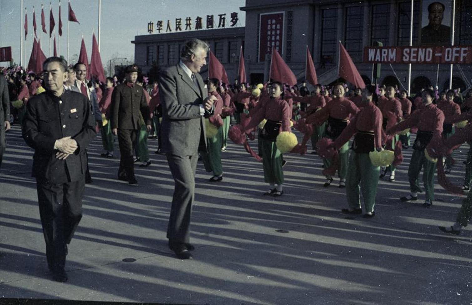 Un ritratto del 1973 di Geoff Whitlam e del Primo Ministro Zhou Enlai circondati da una parata di cinesi con in mano delle bandiere
