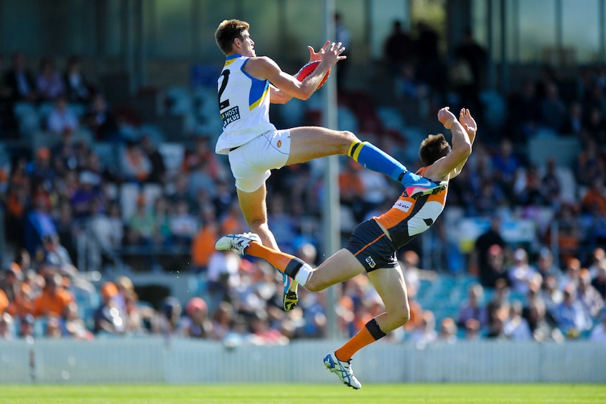 Giant killing ... Gold Coast's Zac Smith marks above GWS's Bret Thornton.