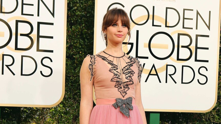 Actress Felicity Jones (nominated in 2015 for The Theory of Everything) dons a pink dress on the red carpet, January 8, 2017.