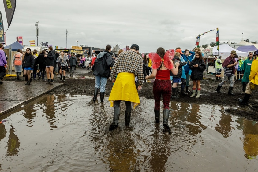 Punters make their way through the muddy Splendour festival site