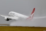 A qantas plane takes off in rainy conditions