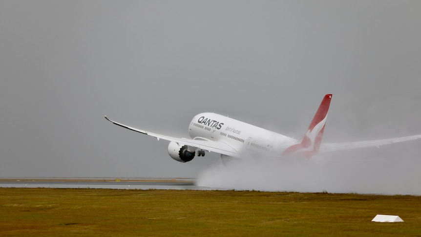 A qantas plane takes off in rainy conditions