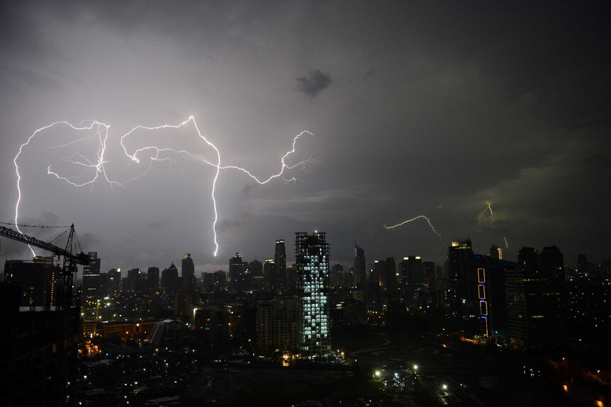 Lightning strikes over Jakarta's skyline during monsoon rains.