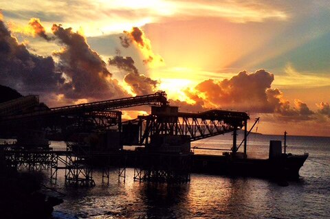 A phosphate loading facility at port on Christmas Island with a sunset in the background.