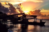 A phosphate loading facility at port on Christmas Island with a sunset in the background.