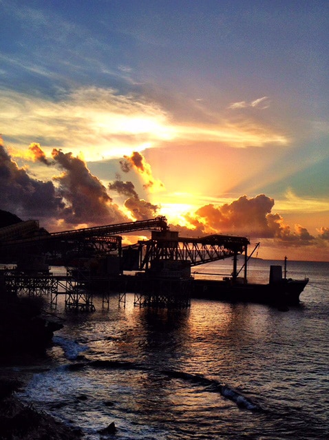 A phosphate loading facility at port on Christmas Island with a sunset in the background.