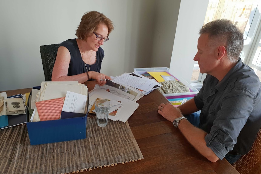 Cynthia Banham reads through letters while her husband looks on