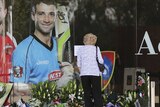 Flowers lay underneath a photo of Phillip Hughes at the Adelaide Oval
