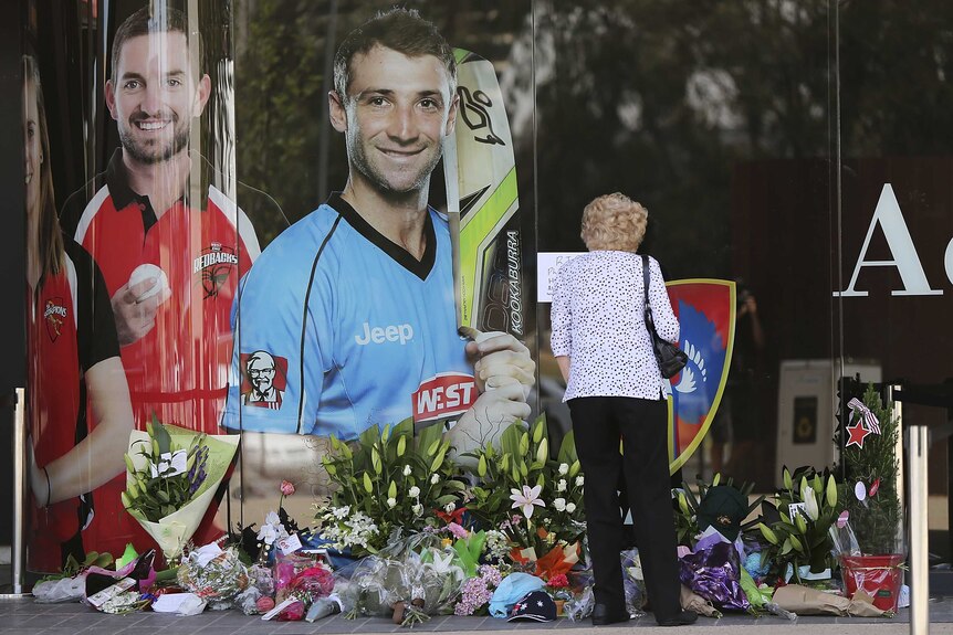 Flowers lay underneath a photo of Phillip Hughes at the Adelaide Oval