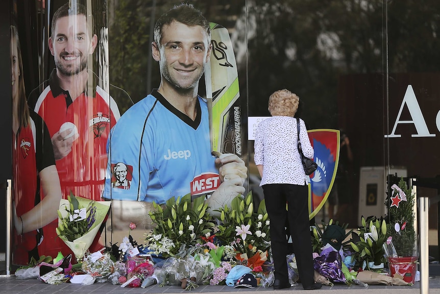 Flowers lay underneath a photo of Phillip Hughes at the Adelaide Oval