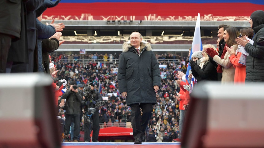 Vladimir Putin arrives to take part in a rally to support his bid in the upcoming presidential election.