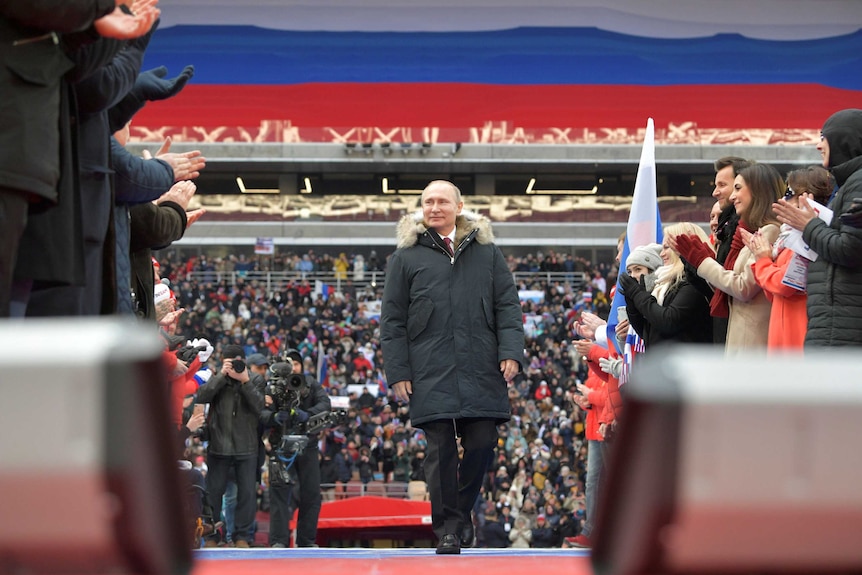 Vladimir Putin arrives to take part in a rally to support his bid in the upcoming presidential election.