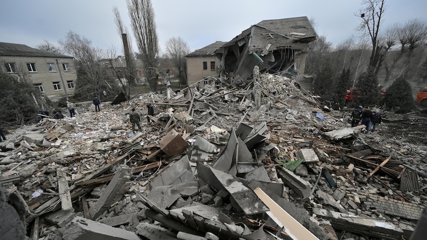 Rescue workers sift through the rubble at the site of a maternity hospital destroyed by air strikes.