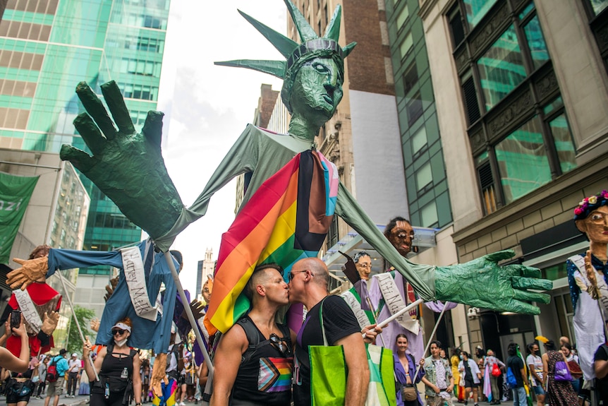 Christopher Williams and his husband Ed Stallsworth kiss while marching