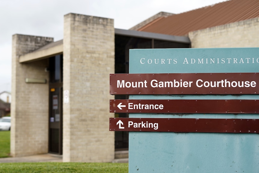 A blue and brown sign reading "Mount Gambier Courthouse" with a brick building in the back