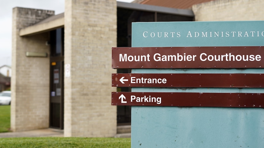 A blue and brown sign reading "Mount Gambier Courthouse" with a brick building in the back