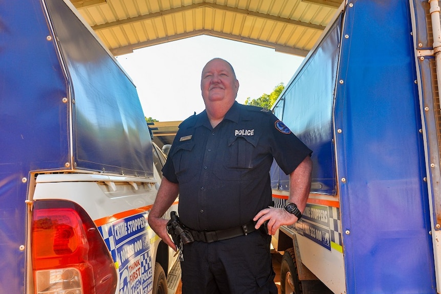 Sergeant Kim Chambers between two cop cars.