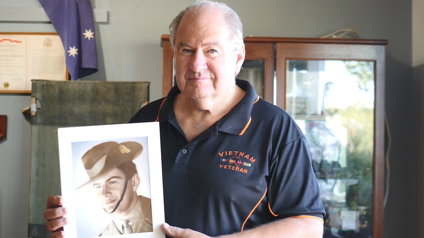 Vietnam war veteran Greg Carter with a photo of himself as a young man.