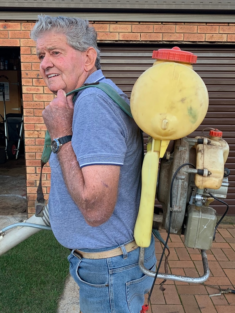 David Vince carrying a chemical sprayer.