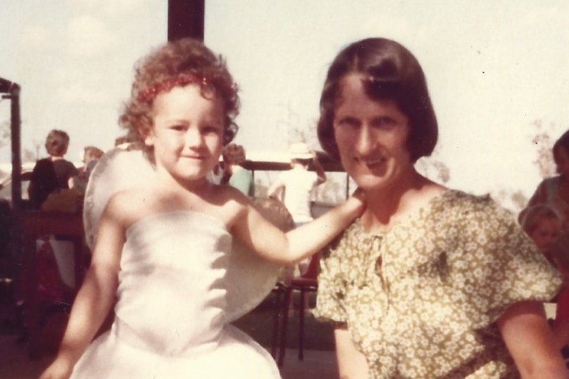 a young child poses for a photo with her mother. They are both happy.