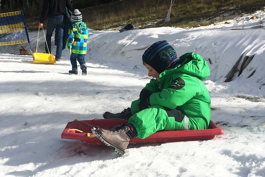 A boy prepares to ride a toboggan at Corin Forest.