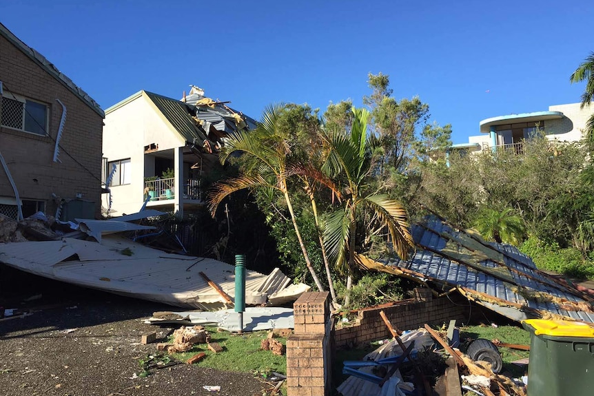 Roof debris scattered over a house and across a lawn in Mooloolaba