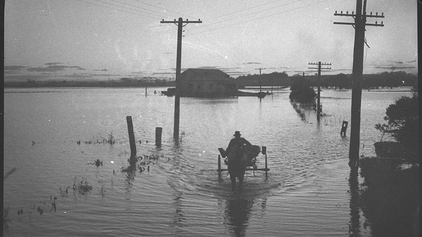 man walks through flood waters