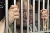 Wu Gan is seen behind bars at a police station.