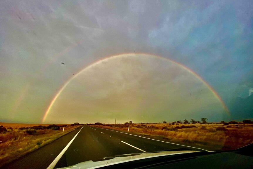 A rainbow across a road.
