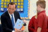 Opposition Leader Tony Abbott displays a card given to him from a class at Penrith Christian School.