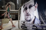 A woman walks past a banner displayed in support of Edward Snowden in Hong Kong