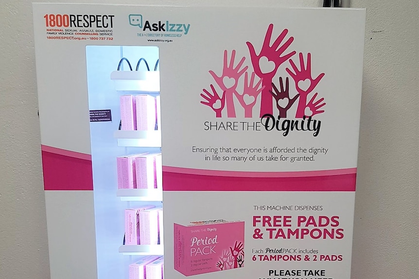 A white and pink vending machine which supplies free period products.